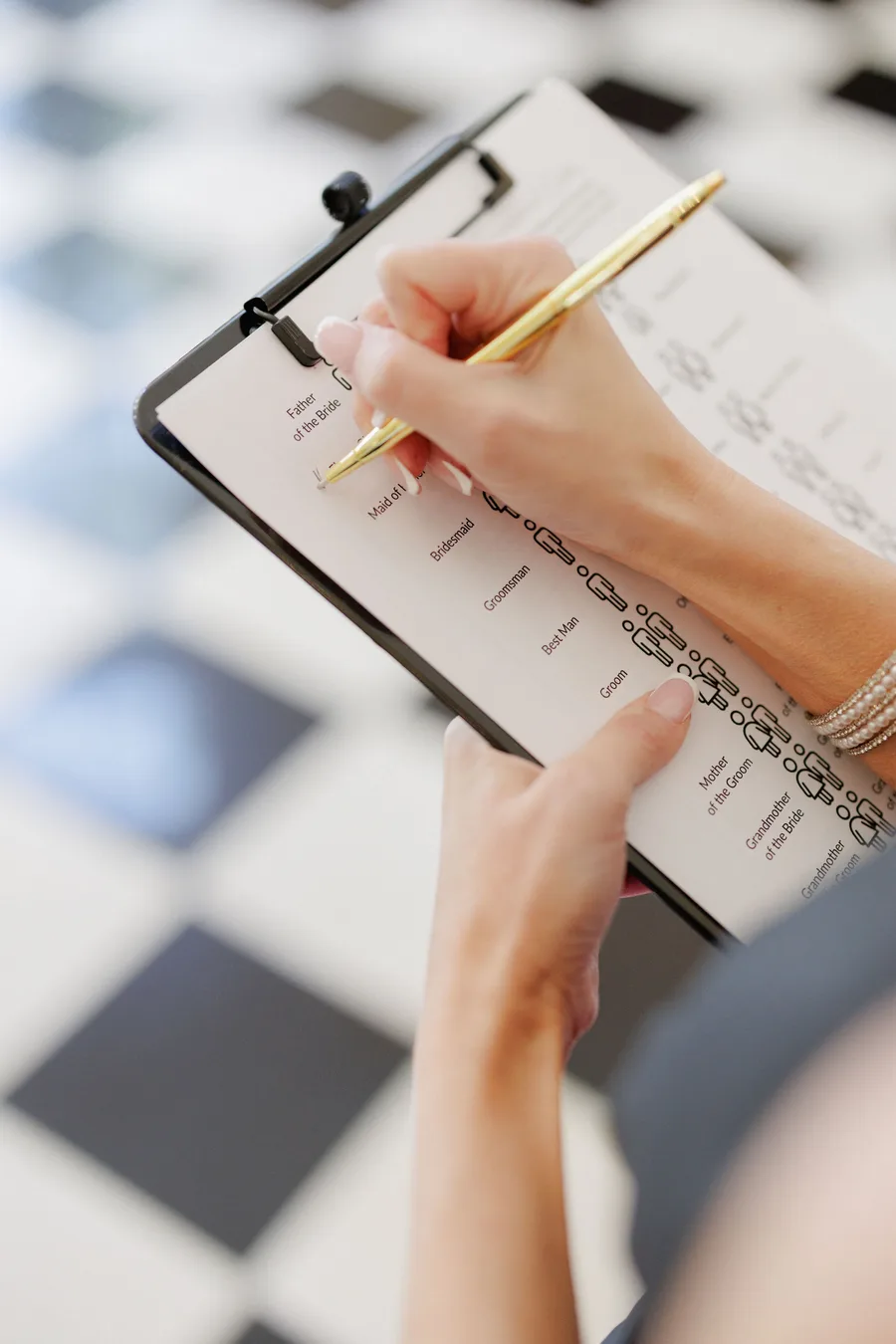 Wedding planner reviewing seating chart on a clipboard