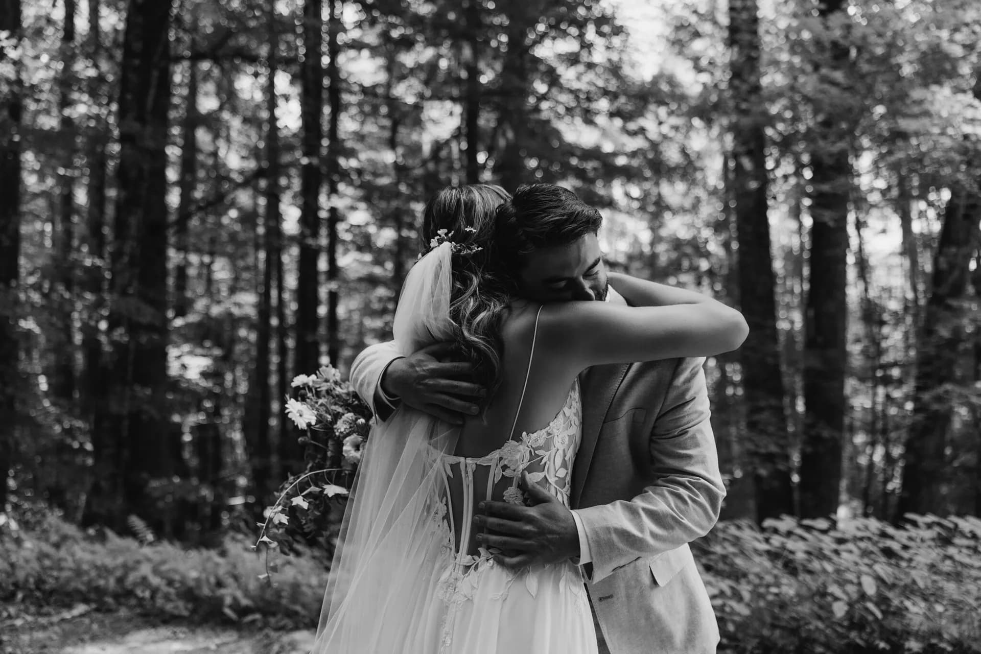 Bride and groom embracing in a sunlit forest