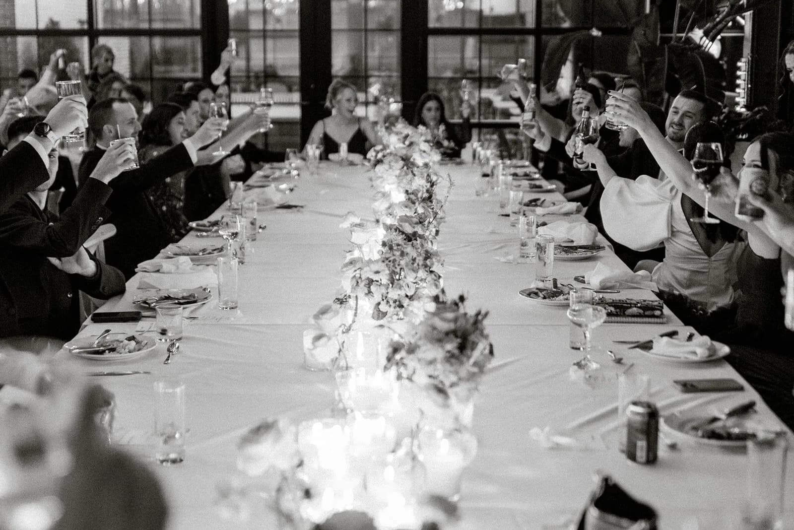 Wedding guests raising glasses at an elegant reception