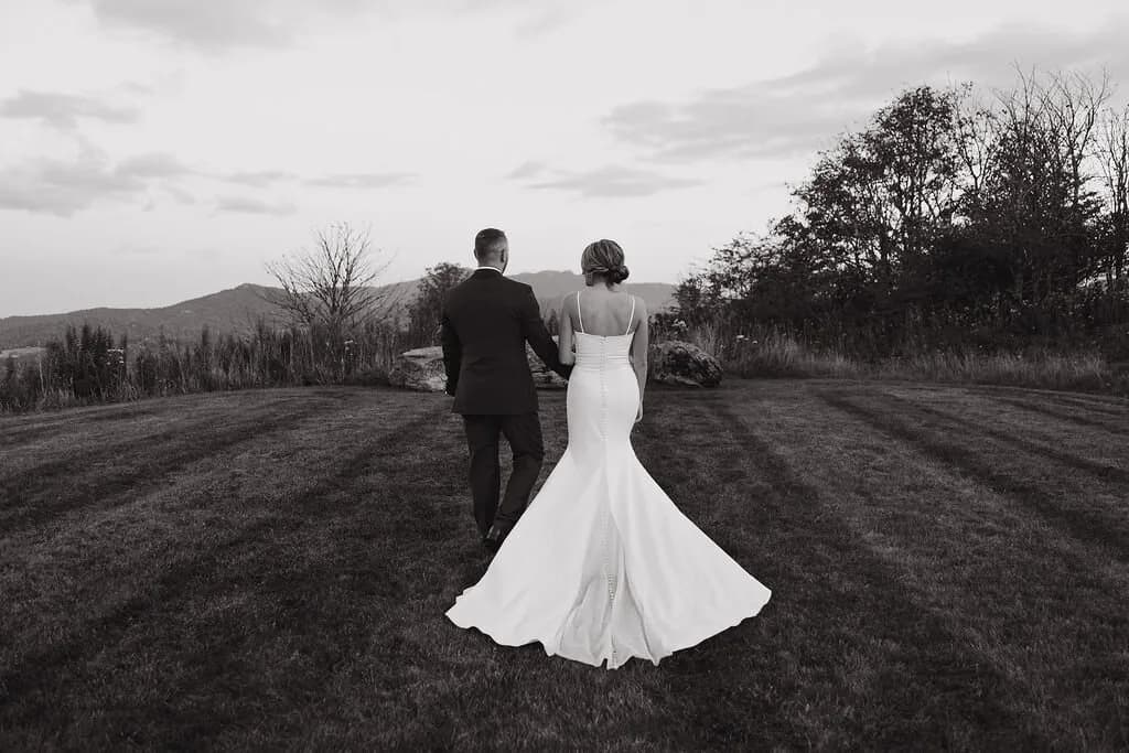 Bride and groom walking in a mountain meadow